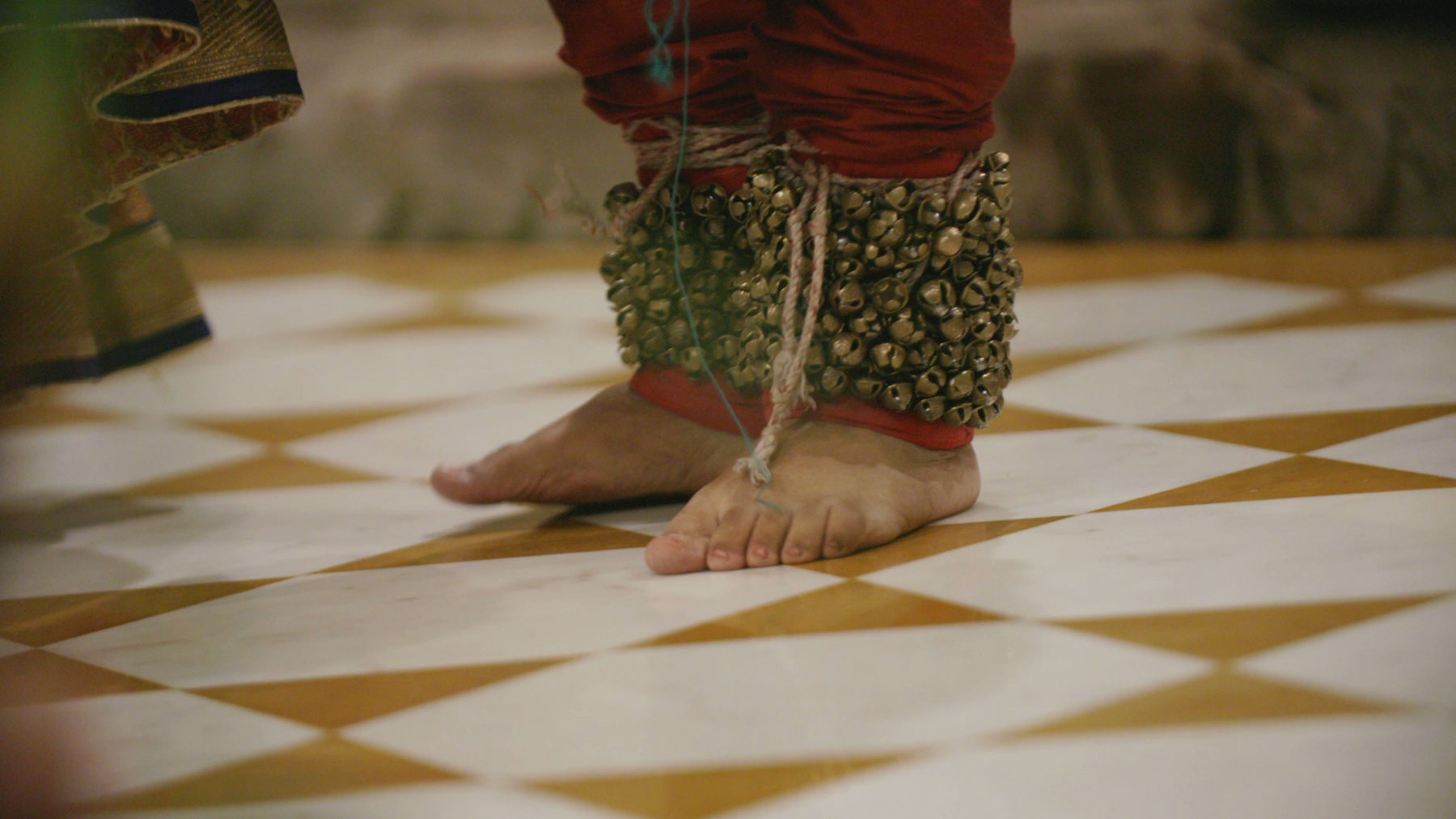 A dancer's ankle bells on a marble floor