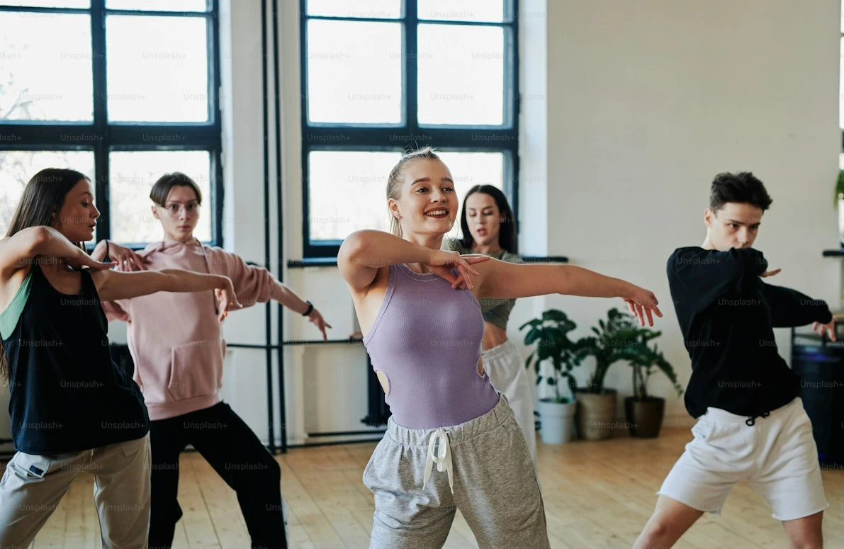 Dancers following an instructor in a bright studio