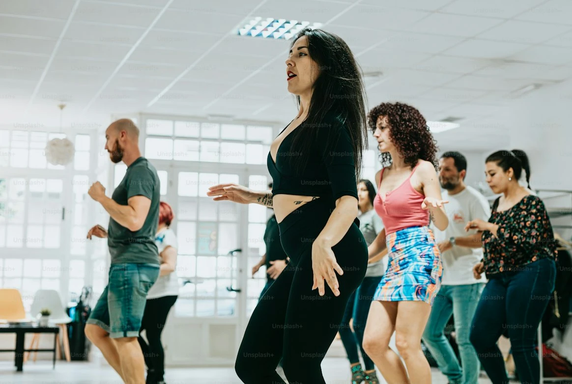 A woman dancing in a class of students